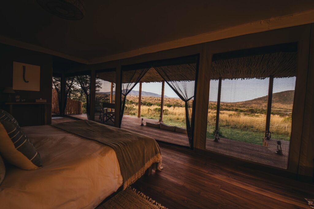 Bedroom interior at Little Enkewa luxury safari tent in the Masai Mara with open views to the savannah