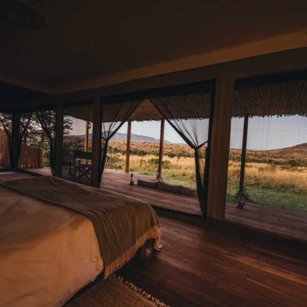 Bedroom interior at Little Enkewa luxury safari tent in the Masai Mara with open views to the savannah